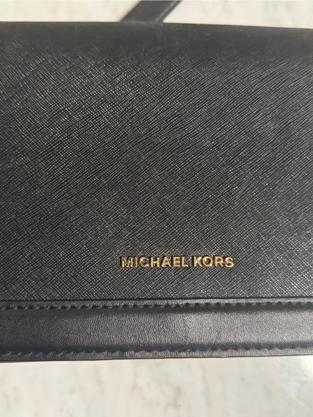 Michael Kors (gold-tone foil/stamp lettering on the front flap).